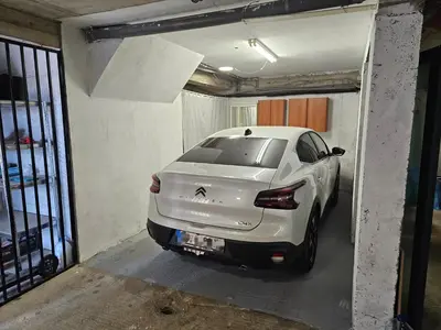 a white car is parked in a garage at Candy apartment central location Bečići in Becici