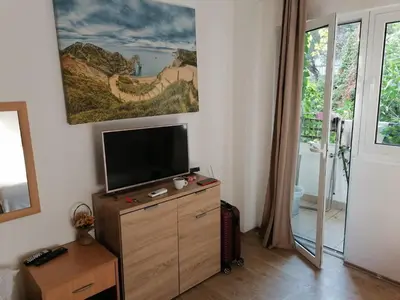 a living room with a flat screen tv on a dresser at Candy apartment central location Bečići in Becici