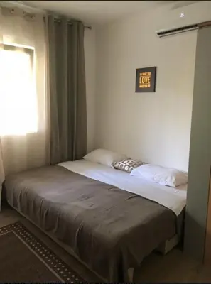 a bed in a bedroom with a clock on the wall at Candy apartment central location Bečići in Becici