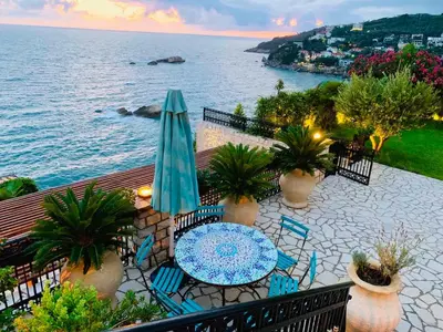 a balcony with a table and chairs and the ocean at Le petit bonheur in Ulcinj