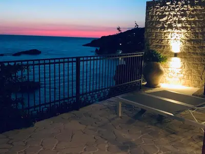 a bench sitting on a balcony looking at the ocean at Le petit bonheur in Ulcinj