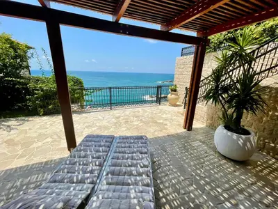a bench on a patio with a view of the ocean at Le petit bonheur in Ulcinj