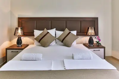 a bedroom with a large white bed with two lamps at Atlantic sobe in Dobra Voda