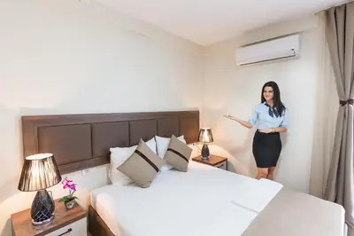 a woman standing in a hotel room with a bed at Atlantic sobe in Dobra Voda