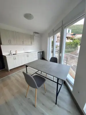 a kitchen with a table and chairs in a room at UpART House in Petrovac na Moru