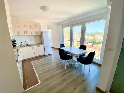 a kitchen and dining room with a table and chairs at UpART House in Petrovac na Moru