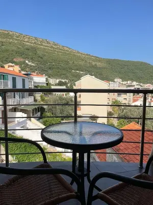 a table on a balcony with a view of a city at UpART House in Petrovac na Moru