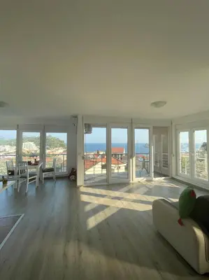 a living room with a couch and views of the ocean at UpART House in Petrovac na Moru