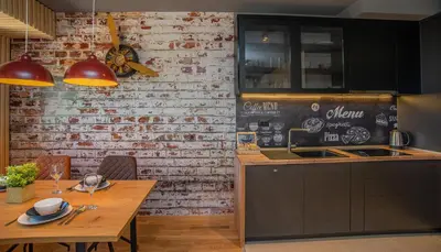 a kitchen with a table and a brick wall at Stylish Two Bedroom Apartment at Ljubovic-Hill Park in Podgorica
