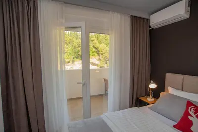 a bedroom with a bed and a sliding glass door at Stylish Two Bedroom Apartment at Ljubovic-Hill Park in Podgorica