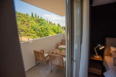 a room with a balcony with a table and chairs at Stylish Two Bedroom Apartment at Ljubovic-Hill Park in Podgorica