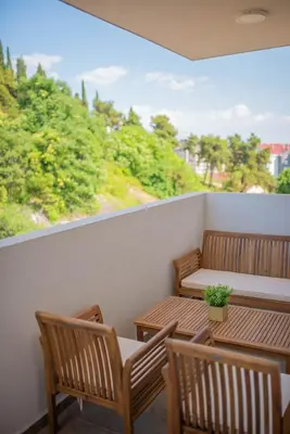 a balcony with two tables and chairs and a view at Stylish Two Bedroom Apartment at Ljubovic-Hill Park in Podgorica