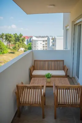 a balcony with two benches and a potted plant at Stylish Two Bedroom Apartment at Ljubovic-Hill Park in Podgorica