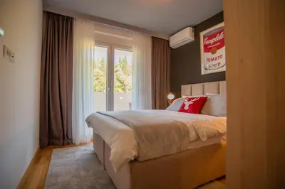 a bedroom with a large bed and a window at Stylish Two Bedroom Apartment at Ljubovic-Hill Park in Podgorica