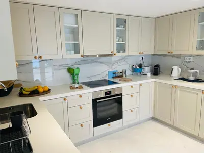 a kitchen with white cabinets and a black microwave at Villa Portico in Budva