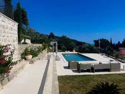 a swimming pool with lounge chairs next to a building at Villa Portico in Budva