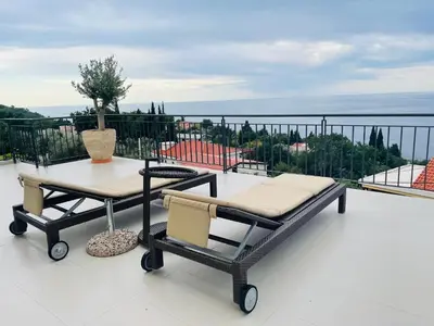 a patio with a table and chairs on a balcony at Villa Portico in Budva
