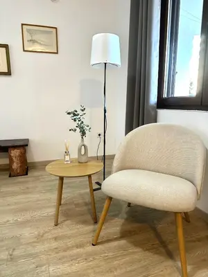 a living room with a chair and a table at Guest house Kamelija in Budva