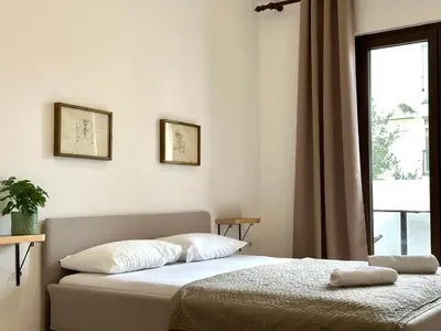 a bedroom with two beds and a window at Guest house Kamelija in Budva