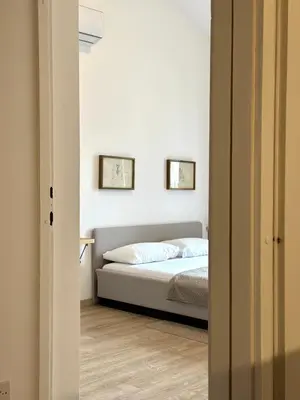 a bedroom with a bed and two pictures on the wall at Guest house Kamelija in Budva