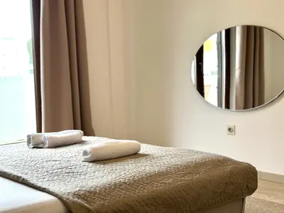 a bedroom with a bed with a mirror on the wall at Guest house Kamelija in Budva