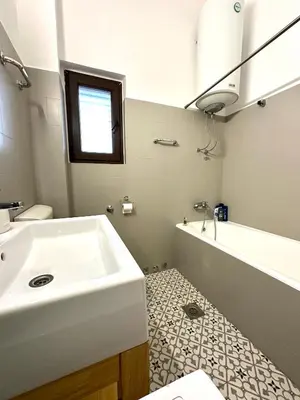 a bathroom with a sink and a tub and a toilet at Guest house Kamelija in Budva