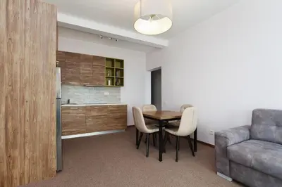 a kitchen and dining room with a table and a couch at Top-hill stunning view 2 bdr apt with swimming pool in Komoševina