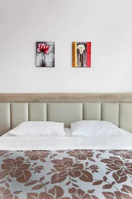 a bedroom with two pictures on the wall above a bed at Top-hill stunning view 2 bdr apt with swimming pool in Komoševina