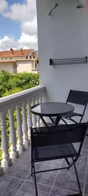 a table and a chair on a balcony at Vila Arb in Ulcinj