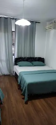 a bedroom with a bed with green sheets on it at Vila Arb in Ulcinj