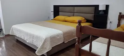 a bedroom with a large bed with yellow pillows at Vila Arb in Ulcinj