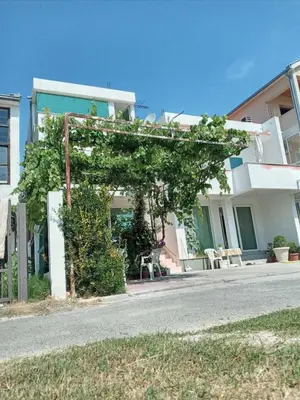 a building with a pergola in front of a street at Vila Arb in Ulcinj