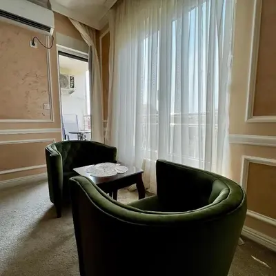a living room with two green chairs and a table at Budva Centar in Budva