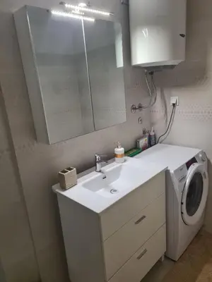 a bathroom with a sink and a washing machine at Budva Centar in Budva
