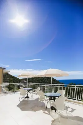 a patio with tables and chairs and the ocean at Villa Blanca in Petrovac na Moru