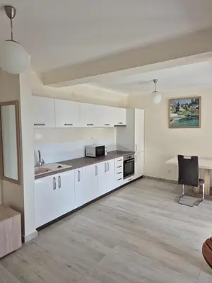 an empty kitchen with white cabinets and a table at Villa Blanca in Petrovac na Moru