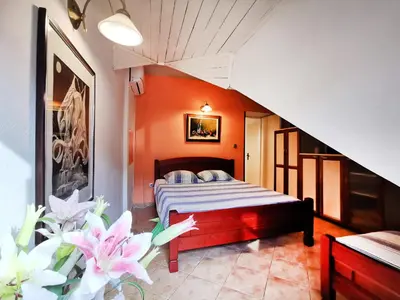 a bedroom with a bed with orange walls and flowers at OLD TOWN 303 in Kotor