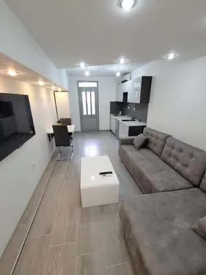 a living room with a couch and a table at Apartment Diamond -modern and lovely seaside studio apartment in Kotor