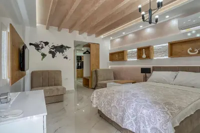 a bedroom with a large bed and a living room at Pearl of Budva in Budva