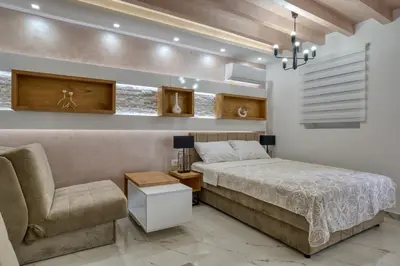 a bedroom with a bed and a chair at Pearl of Budva in Budva