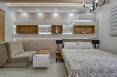 a bedroom with a bed and a couch and a chair at Pearl of Budva in Budva