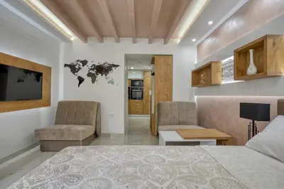 a bedroom with a bed and a couch and a table at Pearl of Budva in Budva
