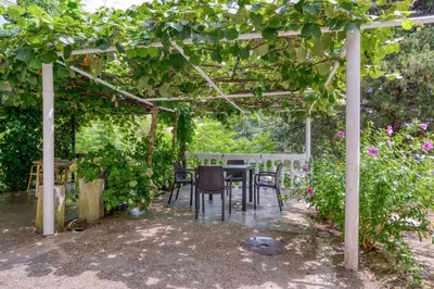 a patio with a table and chairs under a pergola at Pearl of Budva in Budva