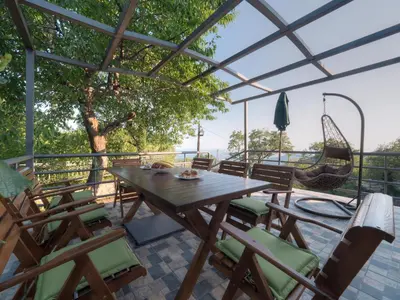 a patio with a table and chairs and a swing at Villa Tranquila in Budva