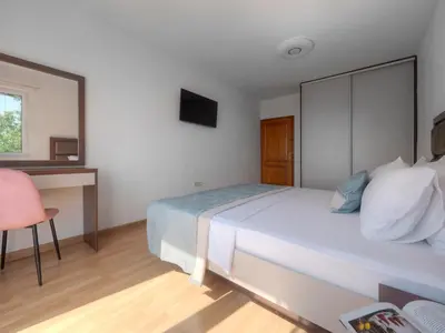 a bedroom with a bed and a desk with a mirror at Villa Tranquila in Budva