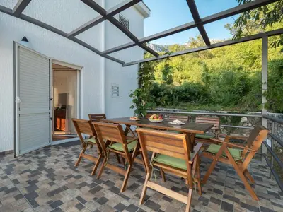 a dining room with a table and chairs on a patio at Villa Tranquila in Budva