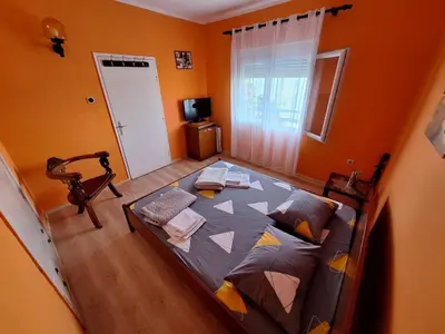 a bedroom with a large bed in a room with orange walls at Sunset in Ulcinj
