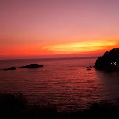 a sunset over the ocean with rocks in the water at Sunset in Ulcinj