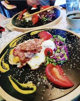 a table with two plates of food on a table at JOX Apartment in Podgorica