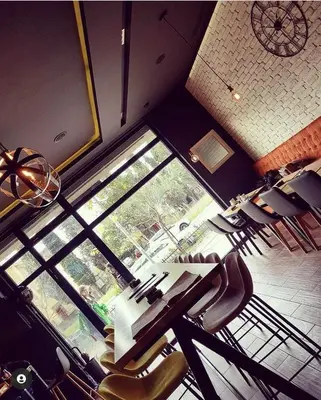 a restaurant with a table and chairs and a window at JOX Apartment in Podgorica